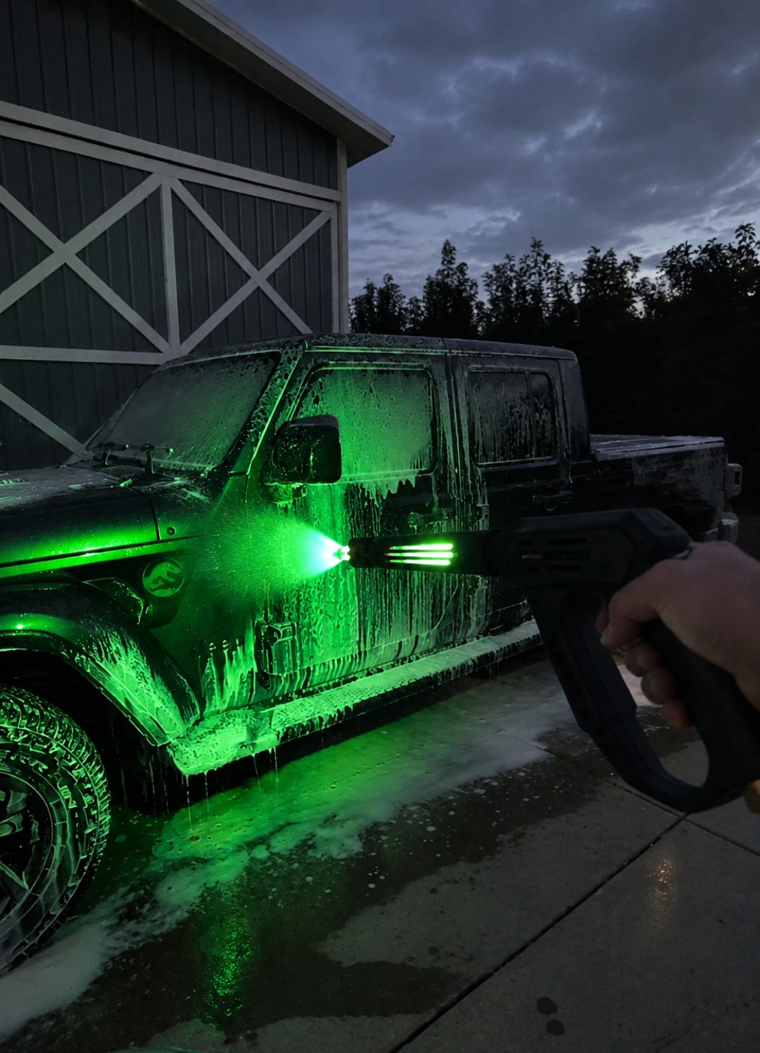 Lightspeed Blaster illuminating water and a wet Jeep in a driveway at dusk