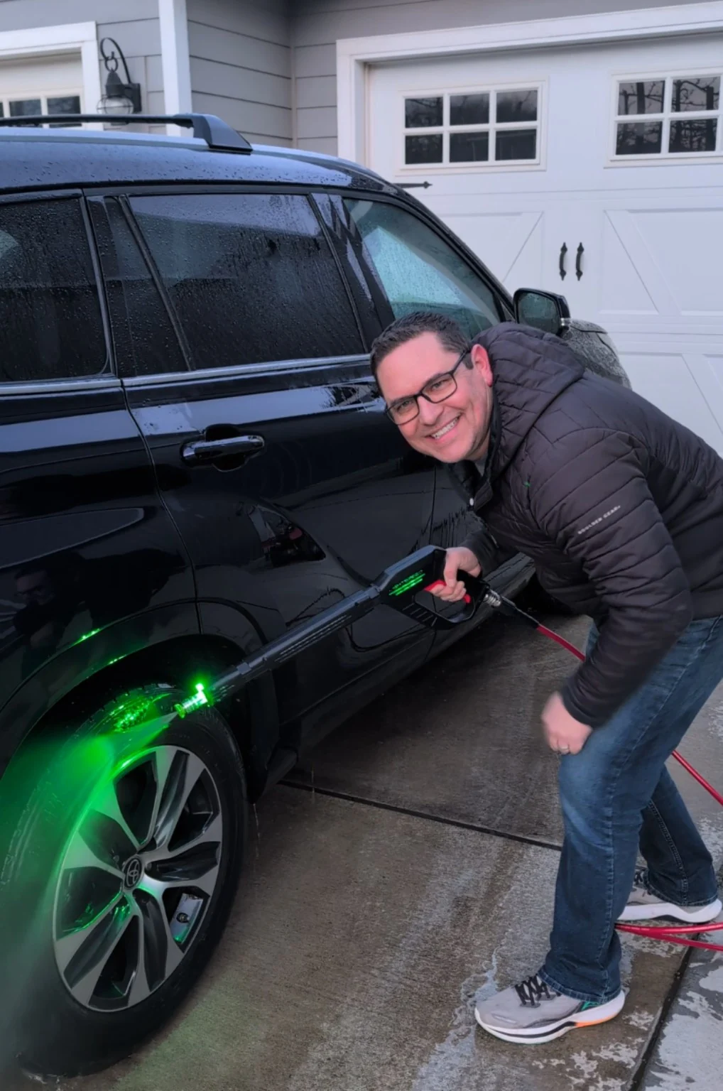 Todd Perkins bent down washing a wheel with green illuminated water during his first Lightspeed Blaster test